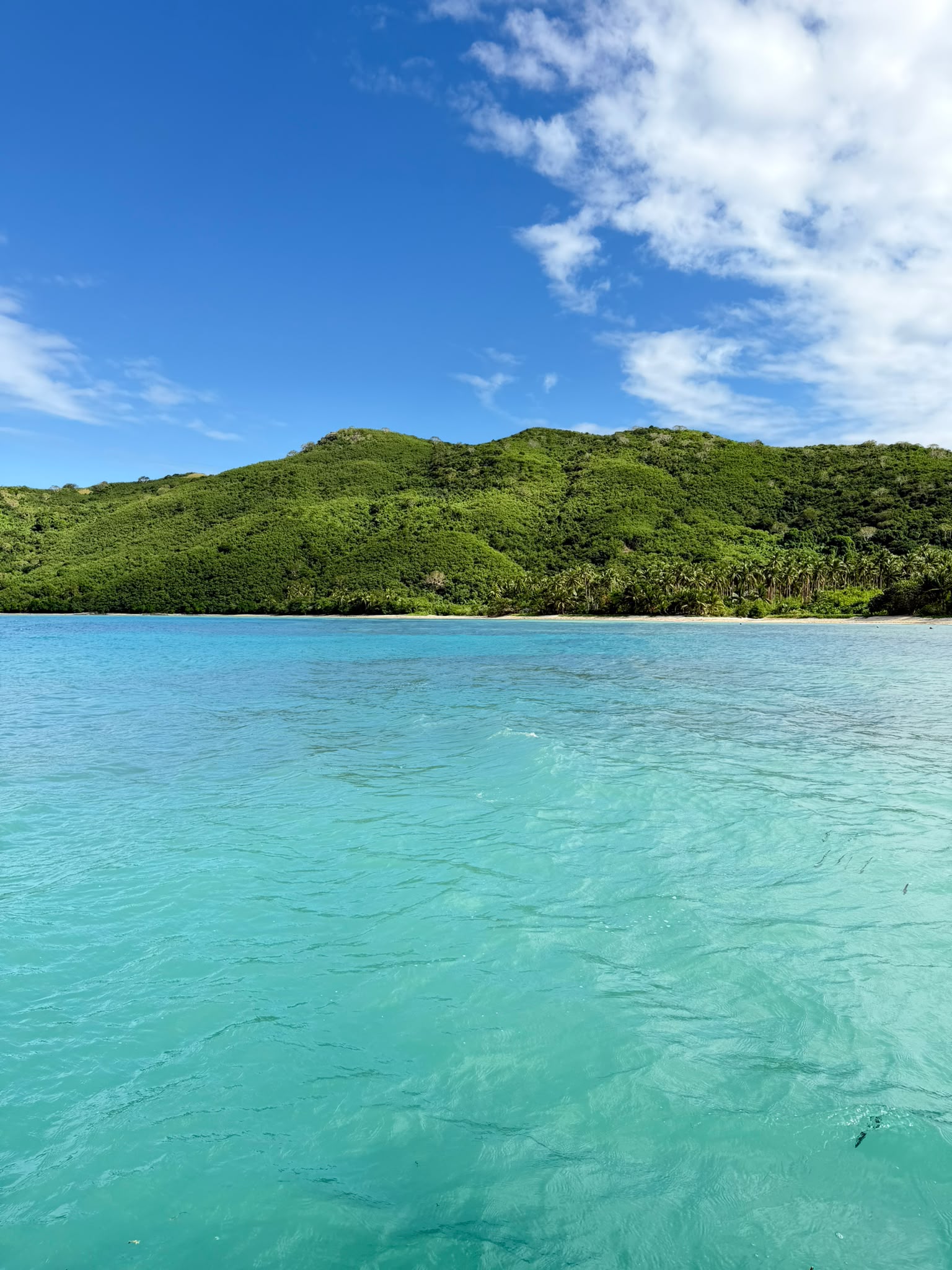 Calm turquoise Pacific waters stretching toward a distant coastline